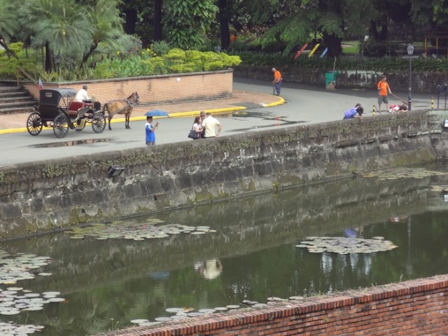 A traditional calesa and domestic tourists, just outside Fort Santiago.