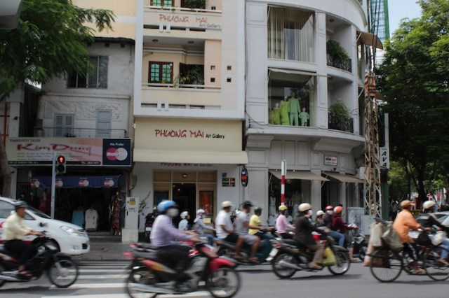 Motorcycles zooming past the Phuong Mai Art Gallery.  