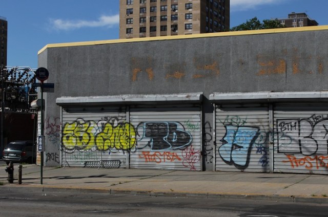2 – Junction of Avenue C, southside: A view of shuttered storefronts, with colourful graffiti.