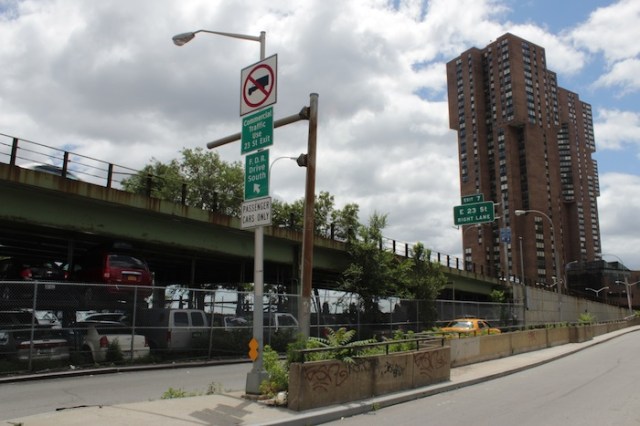 50 – The rust-streaked hulk of the FDR Drive Elevated Highway. Beneath it, a makeshift parking garage. To the right, another dystopian, brutalist apartment block.  