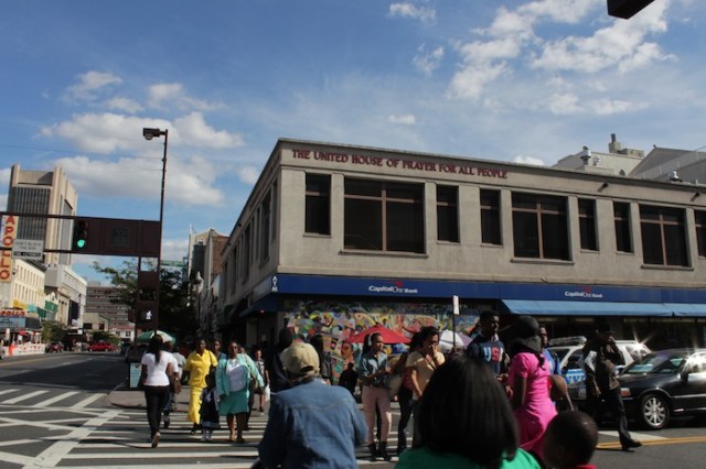 The United House of Prayer For All People, a storefront church on 8th Ave, also known as Frederick Douglass Blvd. Apollo Theater peeks out just beyond. 