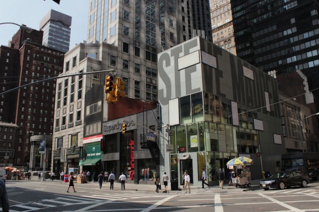 31 – She stands at the southwest side of 58th and Lexington, waiting to cross.  