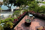 From the swimming pool, looking down upon the ancient, disused well, and further down upon a courting couple along the Avenida da Republica and West Bay Lake.