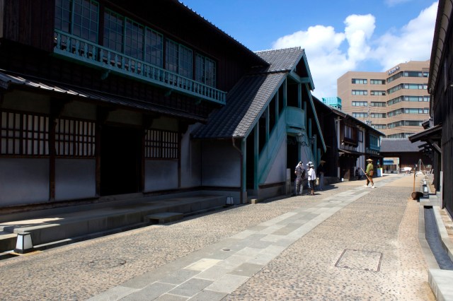 A reconstructed streetscape with a Dutch residence at left. 