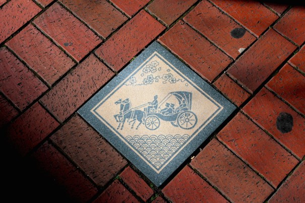 Street tile depicting a horse carriage on Bashamichi. 